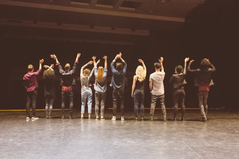 Actors taking a curtain call with their backs to the camera